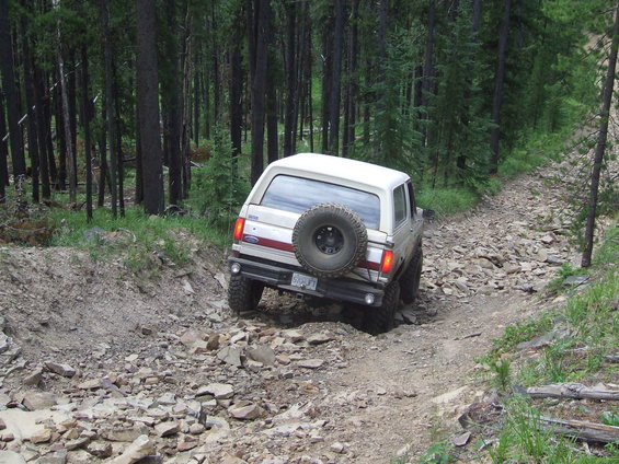 White 1990 Ford Bronco on a rocky mountain trail
