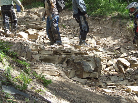 People walking up a steep, rocky trail