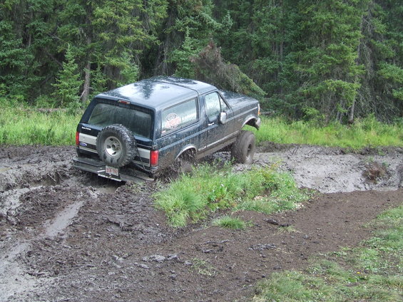 1990 Ford Bronco stuck in mud on a wooded trail