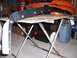 1989 BMW 3 Series - Car fender part on a table, with an orange race car in the background.