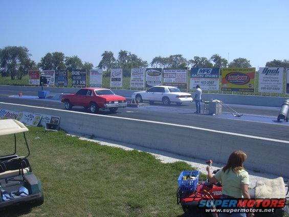 White sedan on drag strip, 3q-front view