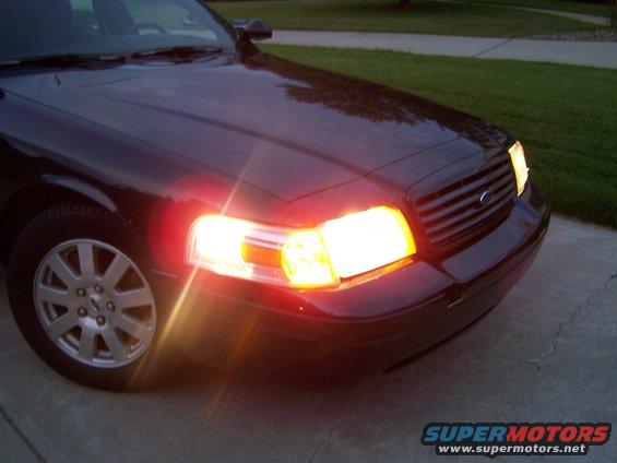 2003 Ford Crown Victoria front corner with headlights on