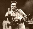 Johnny Cash holding up two fingers while playing guitar