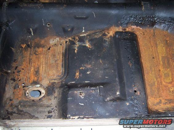 100_1454.jpg the worst of the right floor pan is not really bad at all its mostly what ever they used to seal the bottom - appears to be undercoating and some surface rust and pitting still very very solid