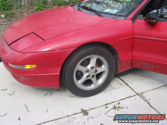 Red 1995 Ford Probe GT with a pop-up headlight and a door ajar