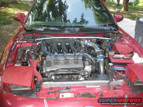 1995 Ford Probe engine bay with aftermarket intake and strut bar