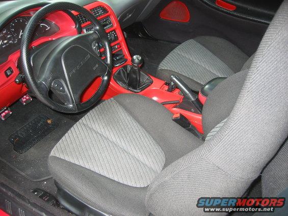 1995 Ford Probe interior with red trim, black steering wheel with 'PROBE' text, and grey seats