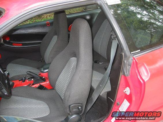 Red car interior with black and grey cloth seats, door panel, and center console