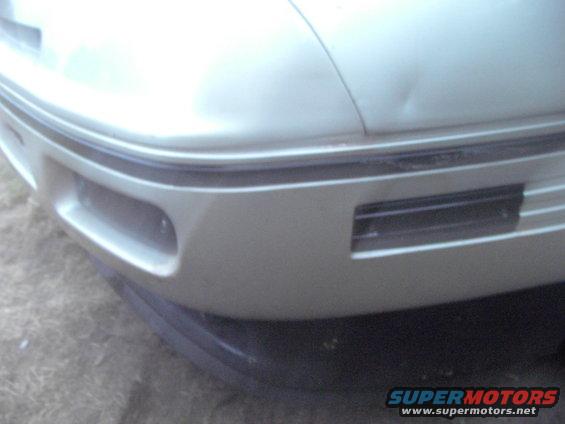 1989 Ford Probe front bumper corner with a dent on the hood