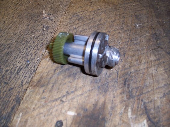 Speedometer drive gear assembly with green plastic gear and metal shaft with threaded end