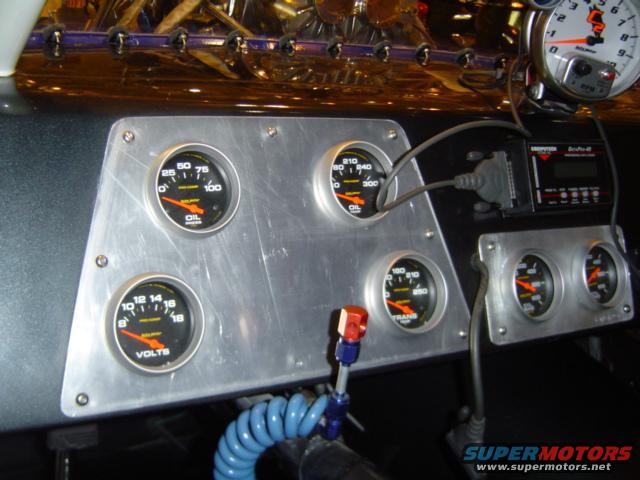 Vehicle dashboard with multiple gauges including oil, volts, and transmission temperature, plus a tachometer