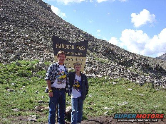 Two people stand at Hancock Pass sign, elevation 12,125 feet