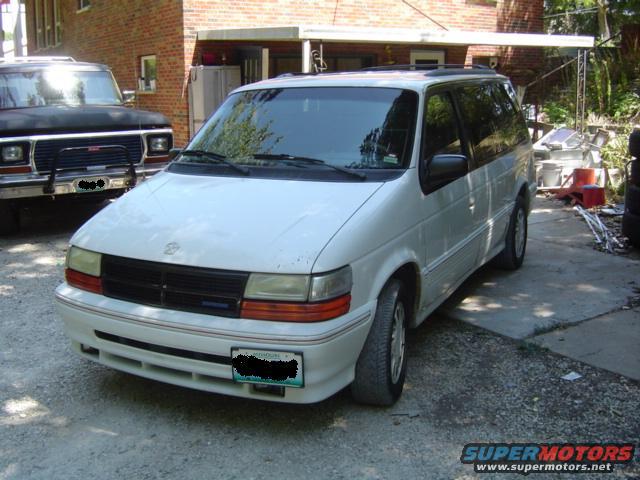 White minivan parked next to a black truck