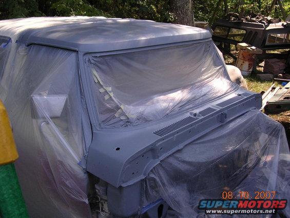 1978 Ford Bronco front end covered in plastic and primer, showing grille detail