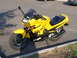 2002 Kawasaki Ninja - A yellow Kawasaki Ninja motorcycle is parked on a paved surface with grass and a curb visible.
