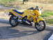 2002 Kawasaki Ninja - A yellow 2002 Kawasaki Ninja motorcycle is parked outdoors on an asphalt surface.