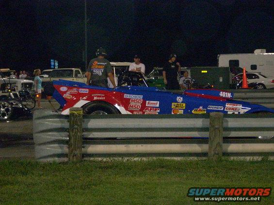 Blue and red drag car with racing decals, side view