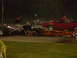 1991 Ford Mustang - Drag racing at night with a dragster and a red muscle car on the track.