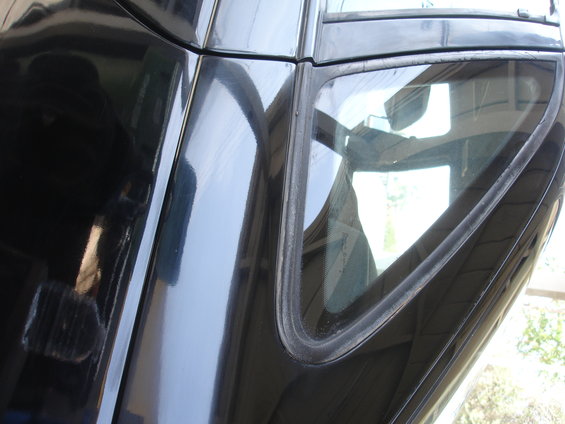 Close-up of black car door panel and triangular window trim