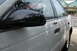 1992 Ford Taurus - The side profile of a white sedan is captured, highlighting its door handles and side mirror.