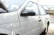 1992 Ford Taurus - A white sedan is parked outdoors with its hood open, revealing a 2000 registration sticker on the windshield.