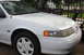 1992 Ford Taurus - The front end of a white 1992 Ford Taurus is visible, showing the headlight and grille area.