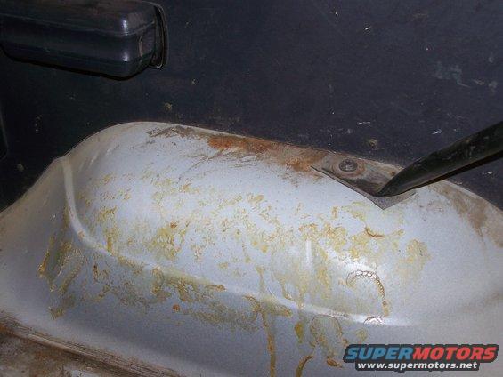 Interior floor pan of a 1986 Ford Bronco showing rust and stains