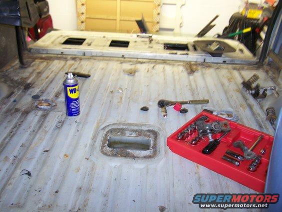 Interior floor of a vehicle with tools and a can of WD-40 laid out