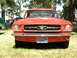 1965 Ford Mustang - A bright red 1965 Ford Mustang is displayed from the front, its iconic grille and emblem.