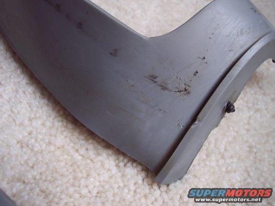 Gray plastic bumper spacer with scratches and a visible screw mount