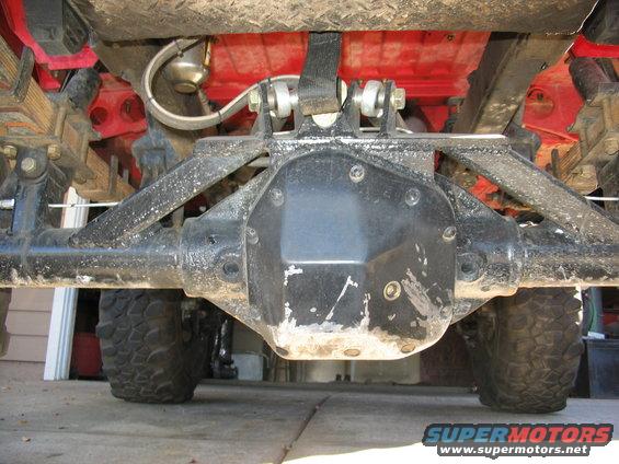 Underside view of a rear differential and suspension parts, with tires visible