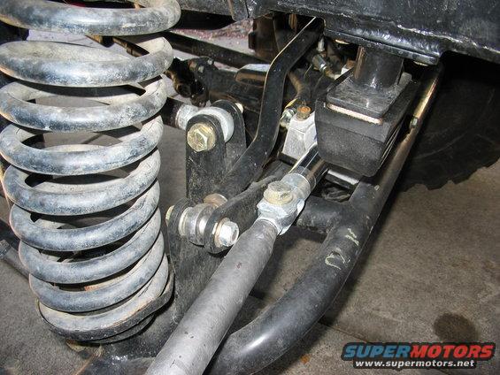 Close-up of suspension components with a SuperMotors.net watermark