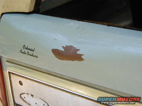 Light blue tailgate with "Colonial Auto Brokers" decal and peeling paint