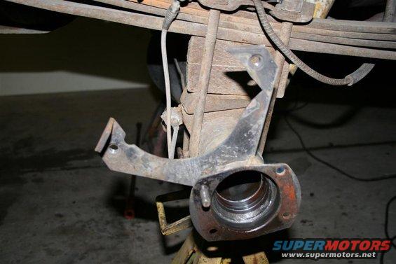 Close-up of a rusty metal suspension part on an axle assembly