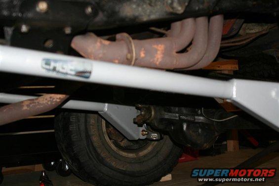 Underbody view showing exhaust manifold, suspension bar with 'CHGE' sticker, and rear axle assembly