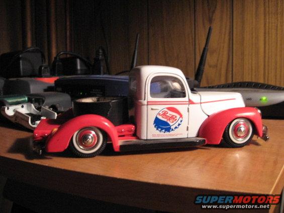 White and red toy truck with Pepsi logo on the side, on a wooden surface