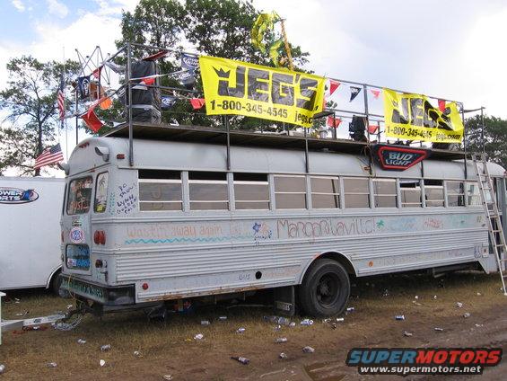 Side view of a decorated bus with "Jegs" banners and "Margaritaville" graffiti