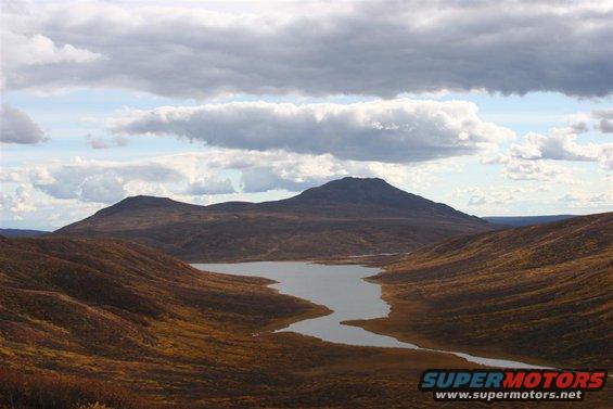 Scenic landscape with lake and mountains under cloudy sky