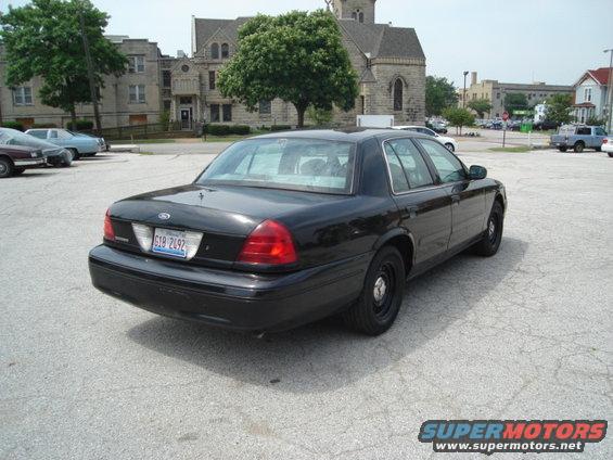 Black 2000 Ford Crown Victoria parked in a lot with buildings in the background