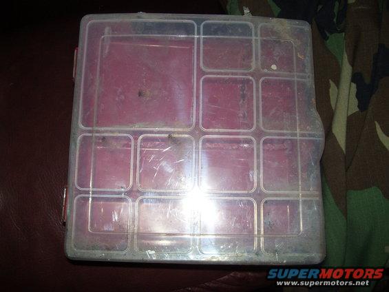Plastic organizer box with multiple compartments, some red dividers visible