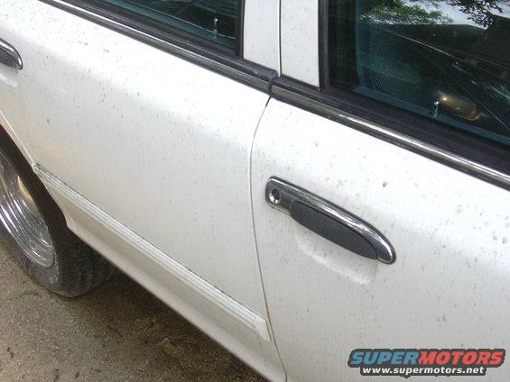White 1997 Ford Crown Victoria side view showing door handle and wheel
