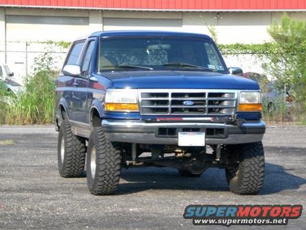 Blue 1996 Ford Bronco with lifted suspension and large tires, front view