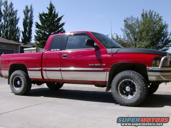 Red Dodge Ram 1500 pickup truck with chrome trim and aftermarket wheels