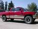 1989 Chevrolet Blazer - Side view of a red Dodge Ram 1500 pickup truck with chrome trim and aftermarket wheels.