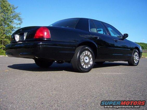 2003 Ford Crown Victoria rear quarter view, black paint, factory wheels