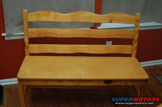 Wooden bench with a curved top backrest and three horizontal slats