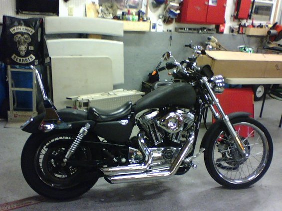 Black 2006 Harley-Davidson Sportster Custom motorcycle parked indoors, side view