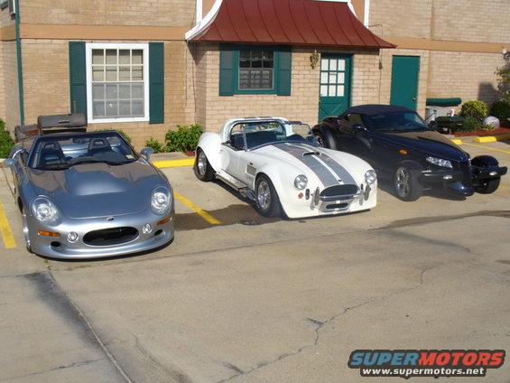 Silver convertible sports car, white striped sports car, and black Prowler parked