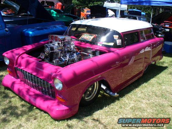 Customized 1955 Chevrolet Nomad with a blown V8 engine, pink paint, and white roof