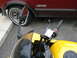 2002 Kawasaki Ninja - A yellow motorcycle's handlebars and mirror are visible next to a red car with 'ASTRO' written on its side.